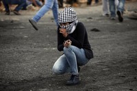 Seorang perempuan Palestina tampak memagang batu. AFP/Abbas Momani.