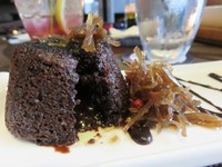 Lava cake di sini berbeda dengan yang umum dijual. Karena sajian kue cokelat ini ditambahkan dengan biji lada merah dan serutan jahe manis yang bikin tubuh semakin hangat. Rasanya unik, karena disajikan dengan sorbet kiwi yang segar.