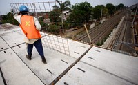 Seorang pekerja menyiapkan rangka besi untuk pembangunan stasiun