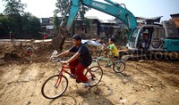 Anak-anak bermain di lokasi proyek normalisasi Kali Ciliwung.
