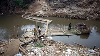 Warga menyeberangi Kali Ciliwung.