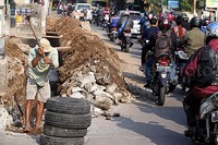 Seorang pekerja sedang melakukan penggalian saluran air.