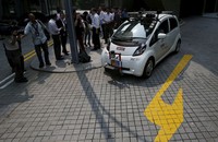 Para jurnalis memperhatikan sebuah mobil tanpa sopir yang mulai melaju di jalanan Singapura. REUTERS/Edgar Su.