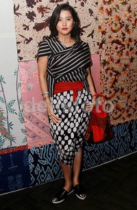 Ia memadukannya dengan bawahan bermotif dengan warna senada dan sepatu slip on hitam dan putih. Kain di pinggang dan tas merah juga melengkapi gayanya. Pool/Gus Mun/detikFoto.