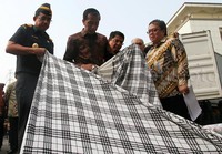 Jokowi mengecek barang tekstil impor ilegal yang berhasil diamankan.