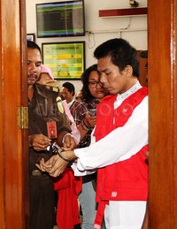 Petugas membuka borgol Robbi. Pool/Lamhot Aritonang/detikFoto.