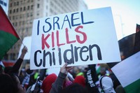 Mereka membentangkan berbagai poster, salah satunya bertuliskan Israel kills children. Scott Olson/Getty Images/AFP.