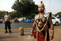 Para mahasiswa menggelar aksi dengan memakai pakaian adat Dayak.
