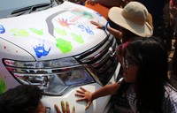 Anak-anak pemilik Nissan Serena juga turut berpartisipasi dalam membubuhkan cap tangan di badan mobil. Ist/Nissan.