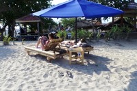 Dua turis bule ini tampak asyik berjemur sambil membaca majalah dan mendengarkan musik. Turis asing memang menyukai Pantai Mawun karena suasananya yang sepi dan tenang. (Wahyu/detikTravel)