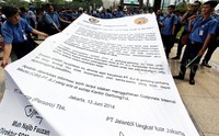 Massa membentangkan spanduk pemberitahuan dari Jasa Marga.