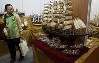 Seorang pengunjung tampak sedang mengamati miniatur kapal di pameran tersebut.
