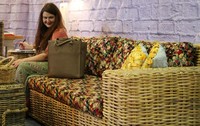 Seorang pengunjung tampak mencoba sofa yang dipamerakan.