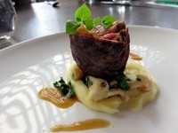 Veal Tenderloin with Parma Ham. Potongan daging sapi muda berjenis wagyu yang lembut dengan balutan Parma Ham. ​Disajikan​ dengan potato puree yang creamy dan tambahan sayur kale plus garlic chips.