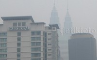 Tampak menara Petronas menjadi remang-remang terselimut asap.