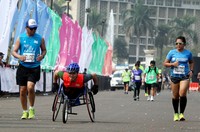 Tak mau kalah dari pelari lain, John (38) peserta dari penyandang disabilitas yang tetap semangat menuju garis finish.