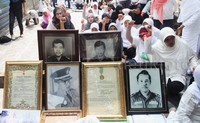 Digerbang masuk kompleks, para warga juga tampak memajang foto-foto keluarga mereka.