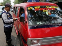Petugas memeriksa surat-surat angkot.