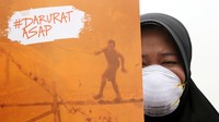 Para peserta aksi memakai masker dan membawa spanduk darurat asap. Safir Makki/CNN Indonesia