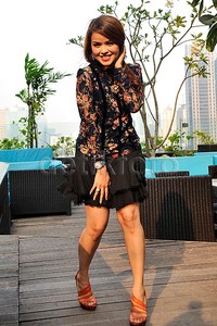 Sambil menahan roknya dari tiupan angin, Siti berpose di depan kamera. Pool/Noel/detikFoto.