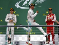 Hamilton melakukan perayaan di atas podium dengan disaksikan Nico Rosberg (kiri) dan Sebastian Vettel (kanan). Mike Stone/Reuters/detikFoto.