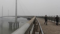 Dua orang warga melintas di Jembatan Pedestrian yang tertutup kabut asap.