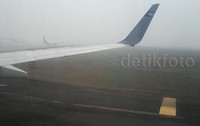 Sebuah pesawat mendarat di Bandara Sutan Mahmud Badaruddin II yang diselimuti asap. Pool/Hans Henricus/detikFoto.