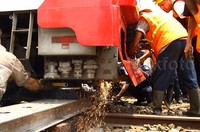 Petugas berusaha mengevakuasi gerbong yang anjlok.
