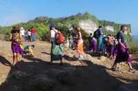 Wisatawan yang datang terlihat sibuk memotret keindahan yang ada. Bagi yang bercelana pendek, diwajibkan memakai kain berwarna ungu dan selendang kuning sebagai sabuknya untuk menjaga kesopanan selama berada di kawasan pura (Wahyu/detikTravel)