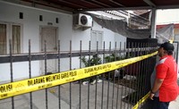 Garis polisi telah dipasang di pagar rumah.