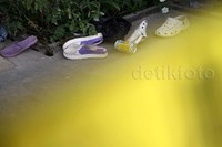Beberapa pasang sandal tergeletak di teras rumah.