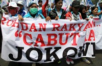 Buruh membentangkan spanduk tuntutan.