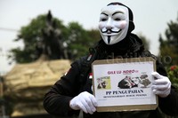 Seorang buruh demo sambil memakai topeng Guy Fawkes.