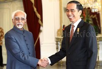 Jokowi berjabat tangan dengan Hamid Ansari.