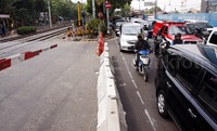 Petugas menutup perlintasan kereta api dengan movable concrete barrier (MCB).
