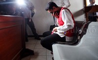 Priyo terus menunduk saat menunggu sidang dimulai.