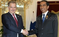 Jokowi berjabat tangan dengan Sauli di dalam istana.