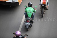 Para pengemudi ojek Go-Jek melintas di jalan Thamrin, Jakarta (3/10/2015).
