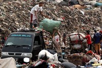 Pemulung mengangkut barang-barang bekas yang bisa didaur ulang.