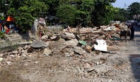 Dua orang pemulung mengais sisa bongkaran.