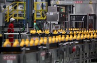 Botol-botol kosong diisi pelumas secara otomatis oleh mesin.‎