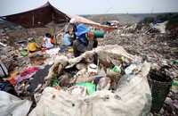 Para pemulung beristirahat di tenda yang didirikan di atas tumpukan sampah.