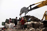 Para pemulung mencari sampah plastik yang baru diturunkan dari truk.