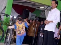 Senangnya seorang bocah setelah mendapat hadiah sepeda dari Jokowi. Cahyo/Setpres.