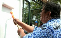Seorang PNS mengecat pagar Monas.