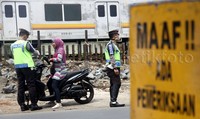 Polisi memeriksa surat-surat pengendara sepeda motor yang tidak memakai helm.