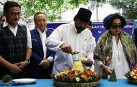 Surya Paloh memotong tumpeng.