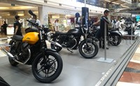 Pengunjung mal mencoba menduduki motor Moto Guzzi yang berukuran cukup besar.