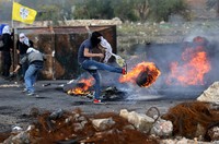 Seorang warga Palestina menendang ban yang dibakar di tengah jalan. Mohamad Torokman/Reuters/detikFoto.
