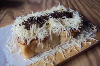 Rotinya lembut dan diberi taburan parutan keju yang royal. Uniknya, di dalam roti terdapat pipilan jagung manis rebus dengan siraman susu kental manis.